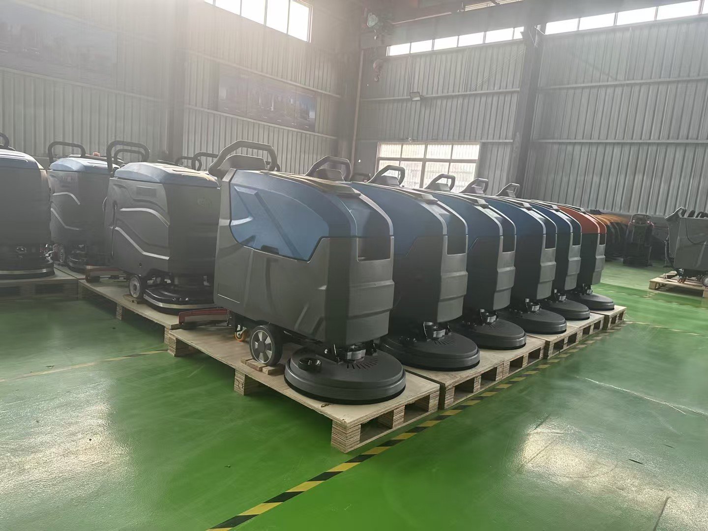 Completed walk-behind floor scrubbers ready in the workshop